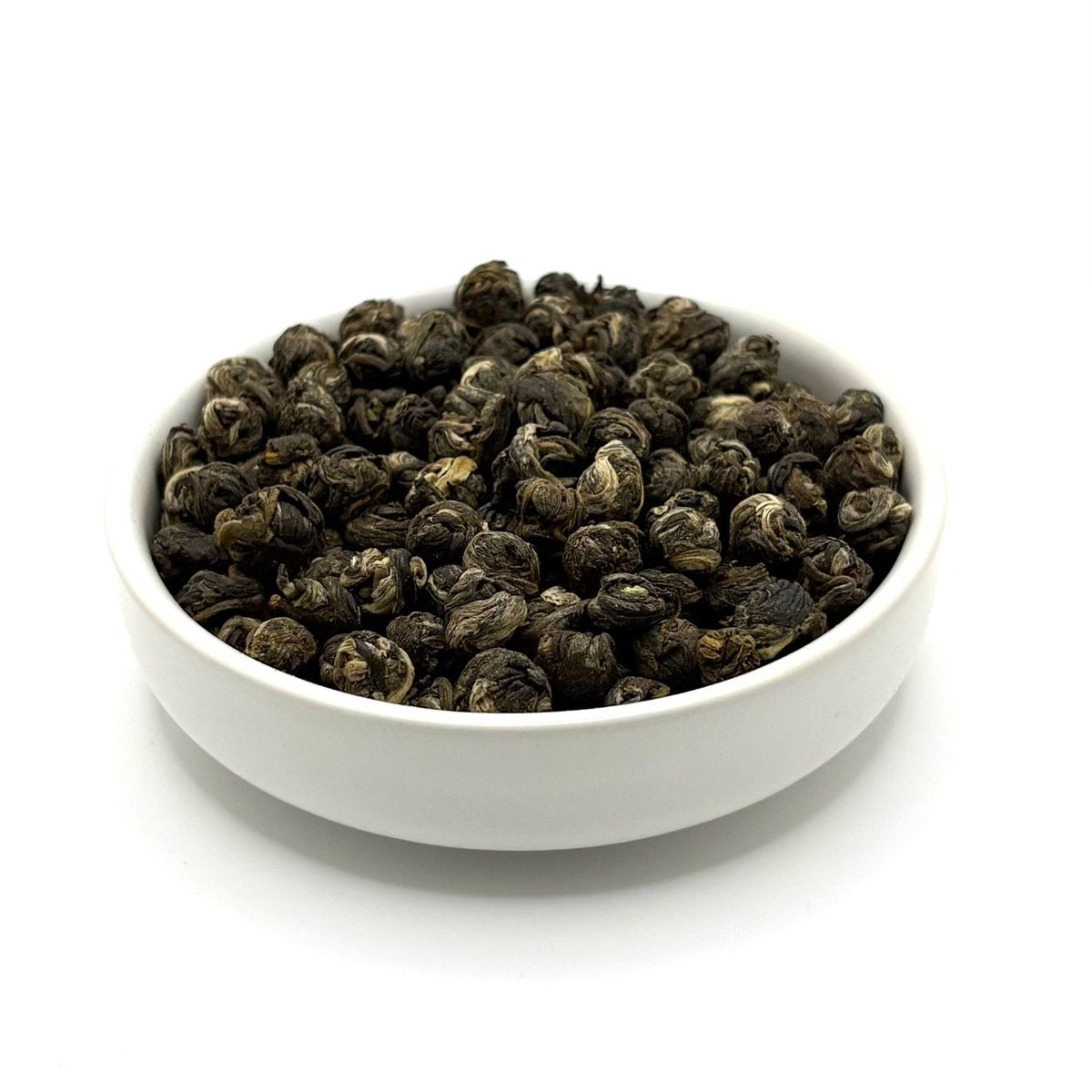 Organic Jasmine Pearls loose leaf green tea close-up in bowl