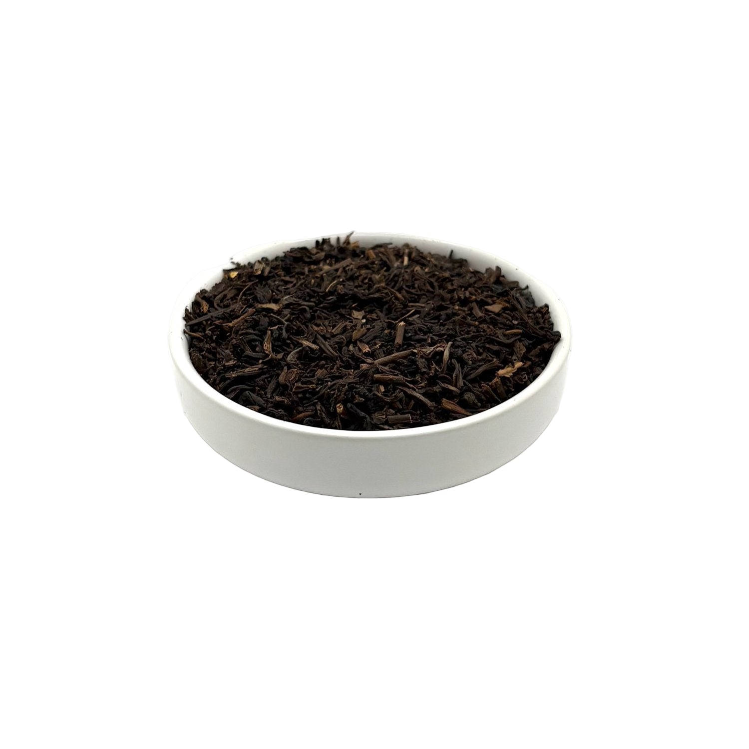 Angled view of Decaf Earl Grey tea leaves showing dark, aromatic curls in white bowl