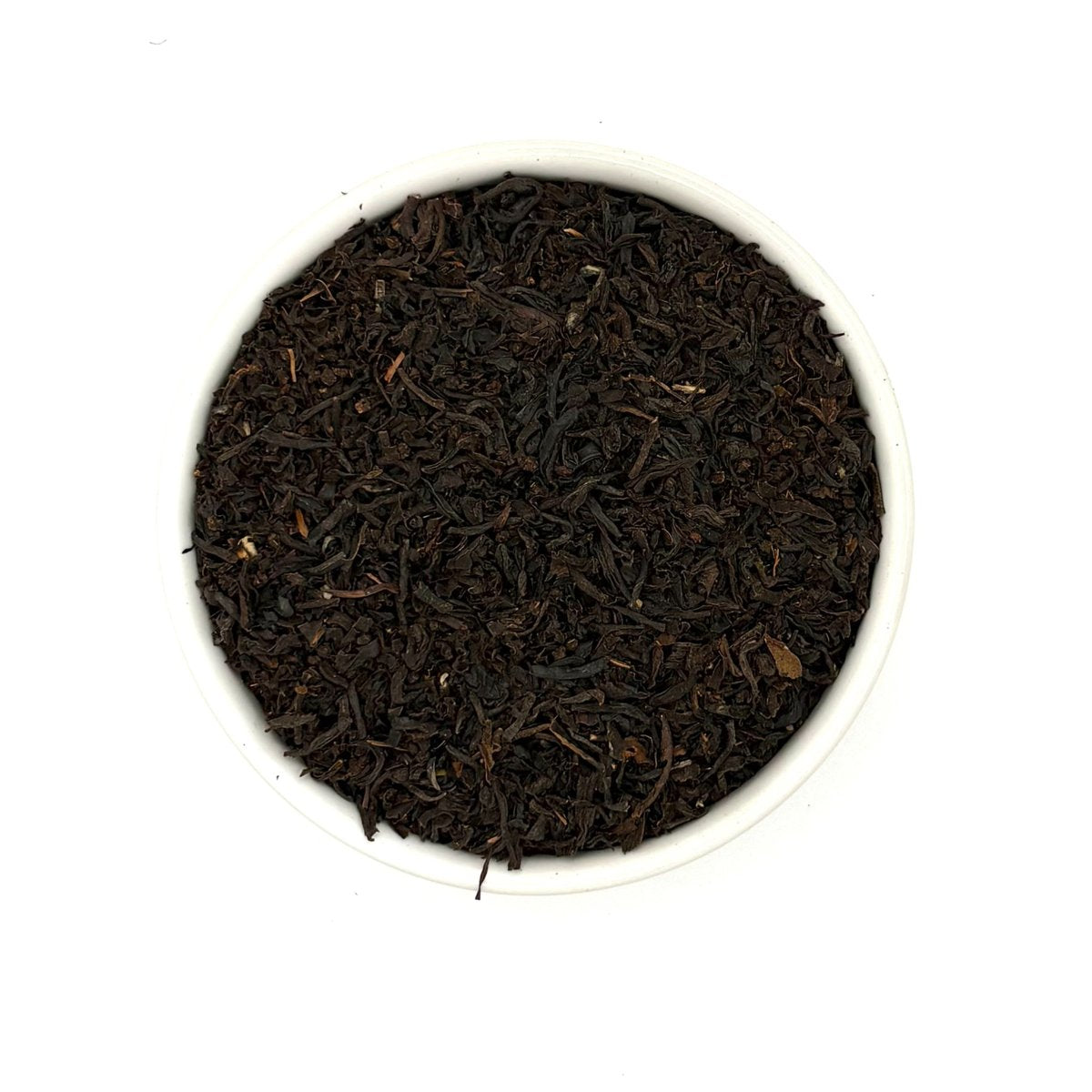 Top view of Assam Banaspati black tea showing rich, dark leaves in a white bowl