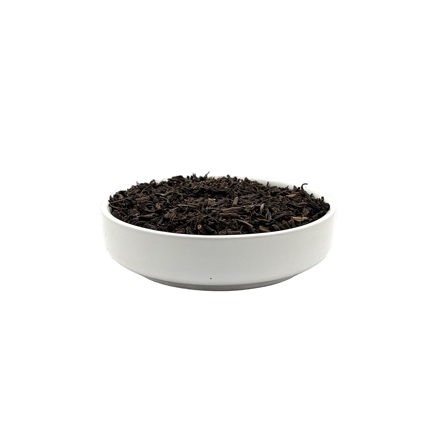 Decaf Earl Grey loose leaf tea in a white bowl, side view with curled black leaves