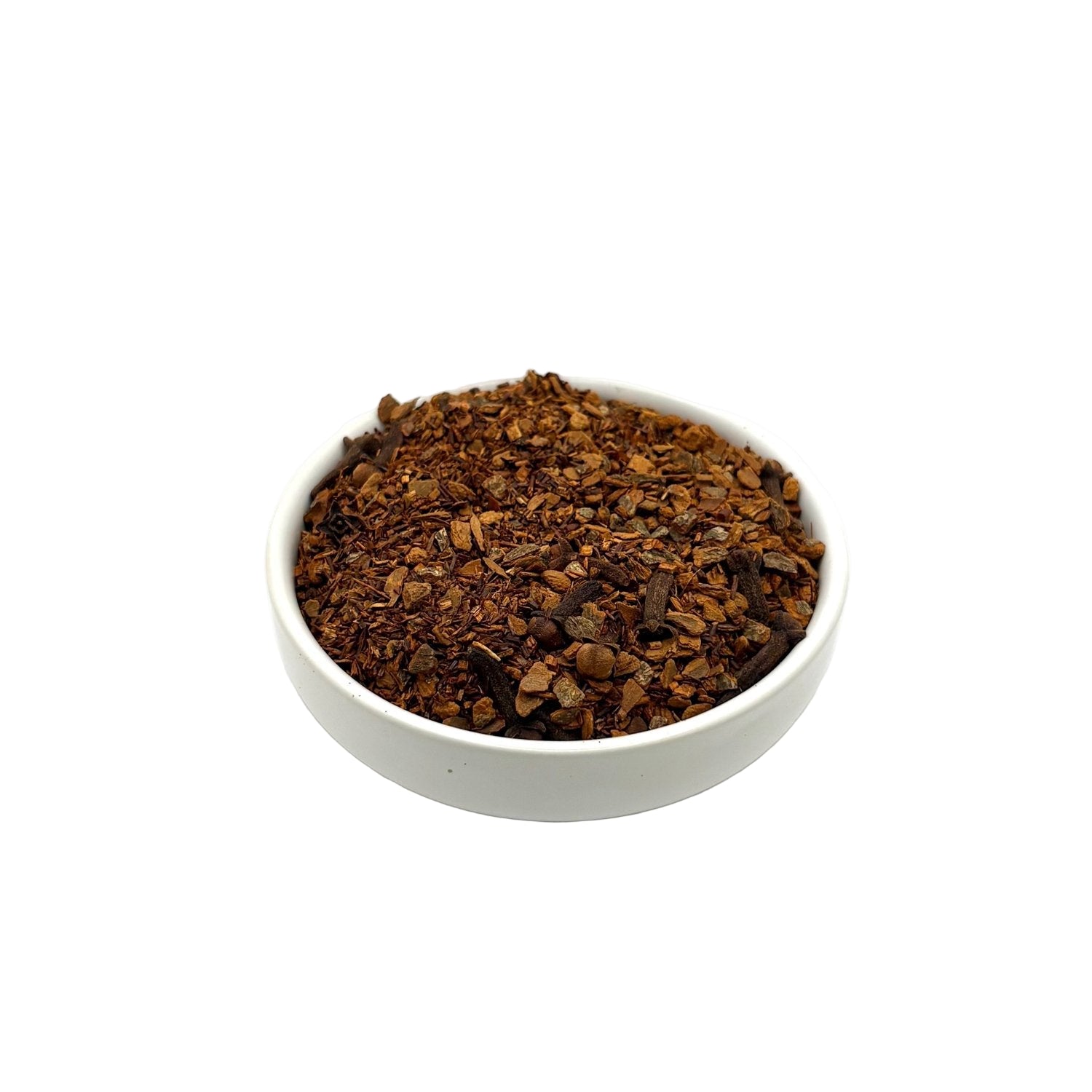 Angled view of rooibos chai tea with visible cloves and cinnamon in ceramic bowl