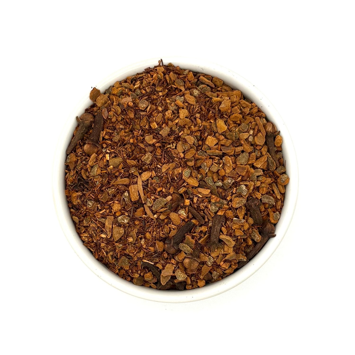 Top-down view of loose leaf spiced rooibos chai tea in round white bowl